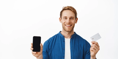 Smiling happy man showing mobile phone blank screen bank credit card recommending smartphone application online shopping app standing white background