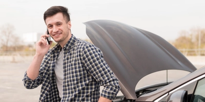 Man with broken car talking phone