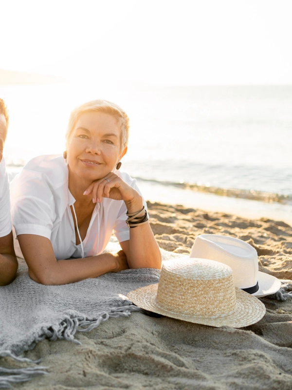 Full shot couple laying towel beach