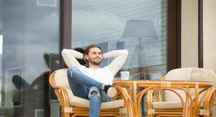 Smiling relaxed man enjoying pleasant morning sitting terrace outdoor