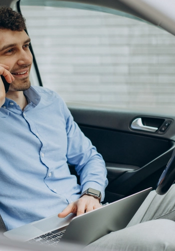 Man working laptop inside his car