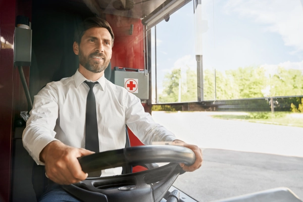 Handsome professional bus driver steering wheel sitting cabin work front view smiling