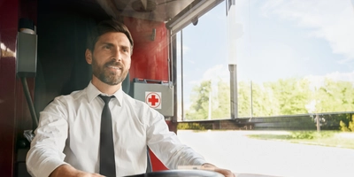 Handsome professional bus driver steering wheel sitting cabin work front view smiling