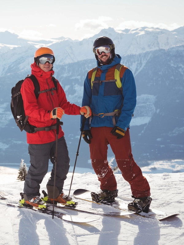Two skiers standing together snow covered mountain