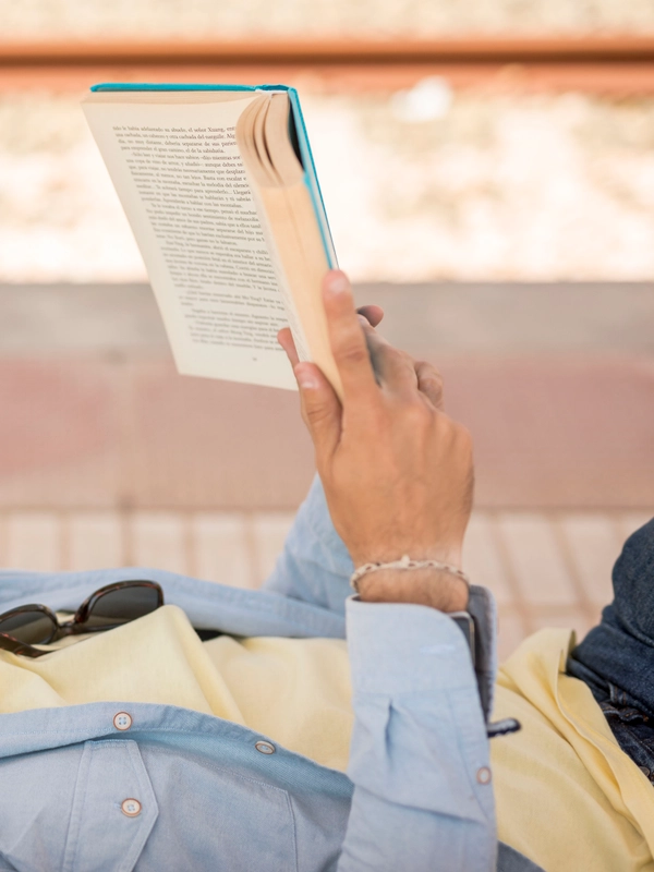 Sideways man reading book train staion