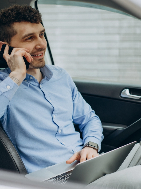 Man working laptop inside his car