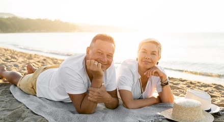 Full shot couple laying towel beach