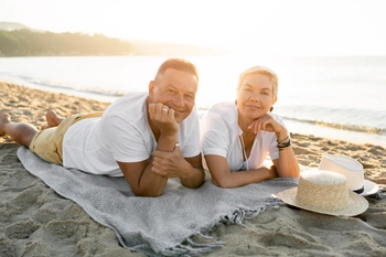 Full shot couple laying towel beach