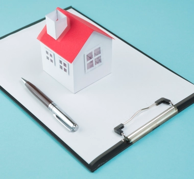 Small house model pen blank clipboard blue backdrop