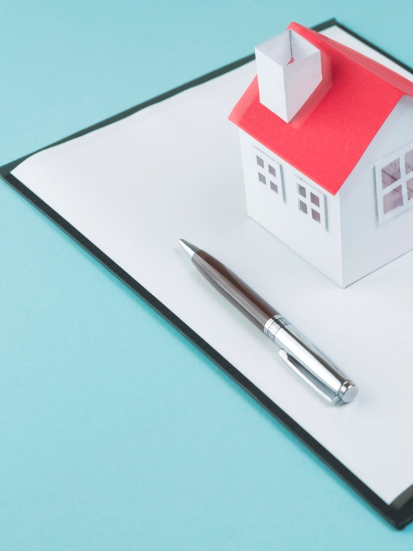 Small house model pen blank clipboard blue backdrop