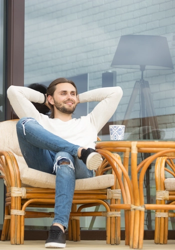 Smiling relaxed man enjoying pleasant morning sitting terrace outdoor