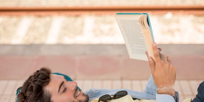 Sideways man reading book train staion