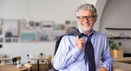 Happy relaxed mature business man standing office cafe leaning counter holding jacket shoulder smiling camera