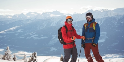 Two skiers standing together snow covered mountain