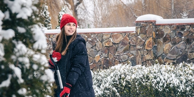 Young woman cleans snow yard snowy weather
